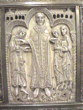 Detalle de uno de los marfiles de la arqueta-relicario que contiene los restos de San Millán, siglo XI.Escena de la vida del santo revestido de sacerdote flanqueado por San Aselo a la derecha, y Santos Geroncio y Sofronio a la izquierda.