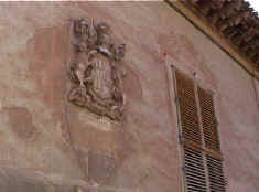 Escudo imperial en fachada adornada de antiguas pinturas