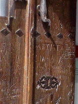 Puerta del museo plagada de graffitis hechos a navaja