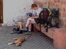 dos recin llegadas descansan  a la sombra de la iglesia, junto a la puerta del albergue.