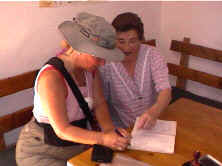 Brigitte firma en el libro de registro bajo la mirada de María