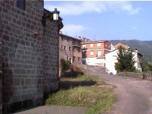 Calle del pueblo con el abside a la izquierda 