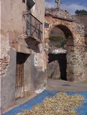 Secando al sol las famosas legumbres de Pedroso junto al arco que conduce a la ermita