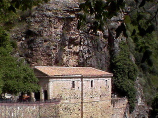 Ermita de exvotos bajo el farallón rocoso