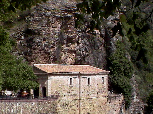 Ermita de exvotos bajo el faralln rocoso